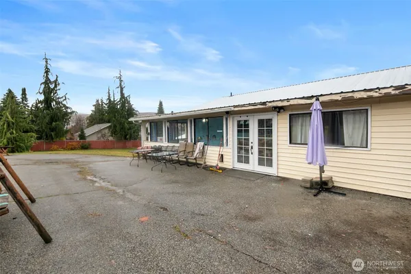 a view of a house with backyard and parking area