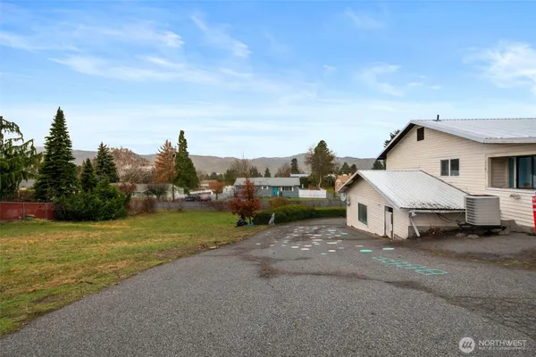 a view of a house with backyard and trees