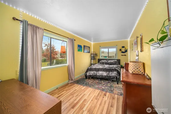 a spacious bedroom with a bed and wooden floor