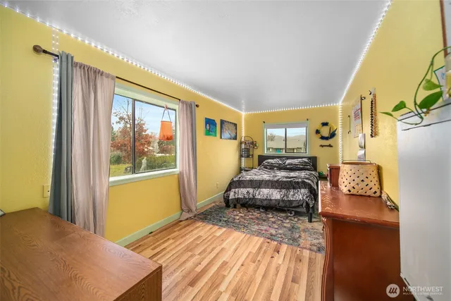 a spacious bedroom with a bed and wooden floor