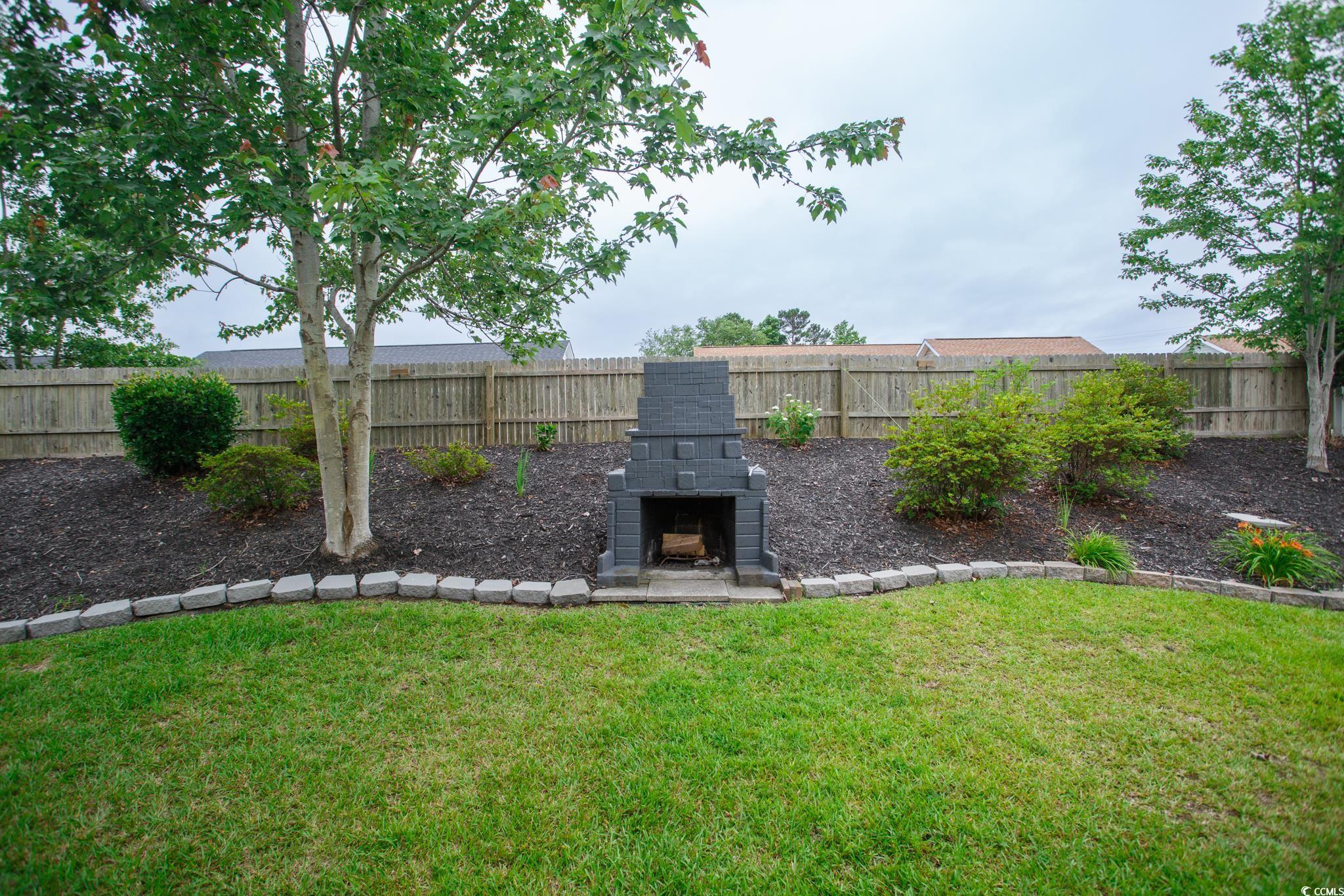 112 Molinia Drive Murrells Inlet, SC 29576 - Photo 18 of 40 View of yard with an outdoor stone fireplace