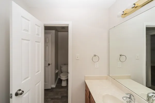 a bathroom with a granite countertop sink a mirror and shower