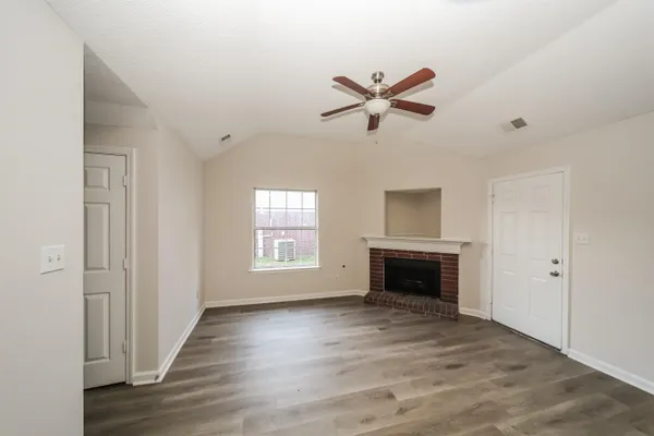 a view of an empty room with a window and fireplace