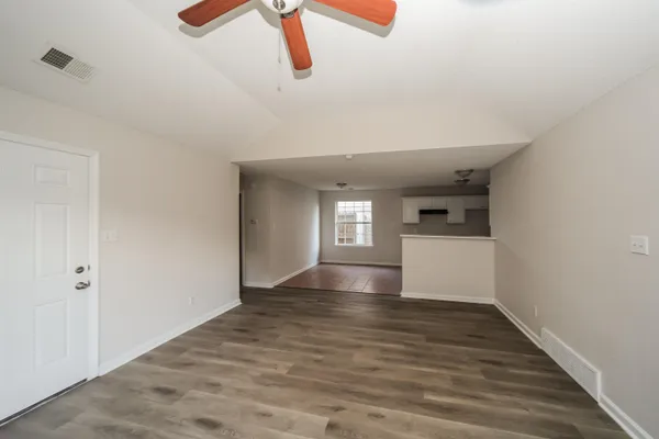 a view of empty room with wooden floor and window