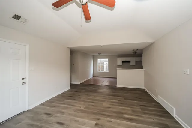 a view of empty room with wooden floor and window