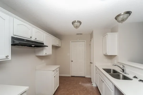 a kitchen with a sink a stove and cabinets