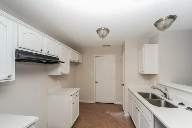a kitchen with a sink a stove and cabinets