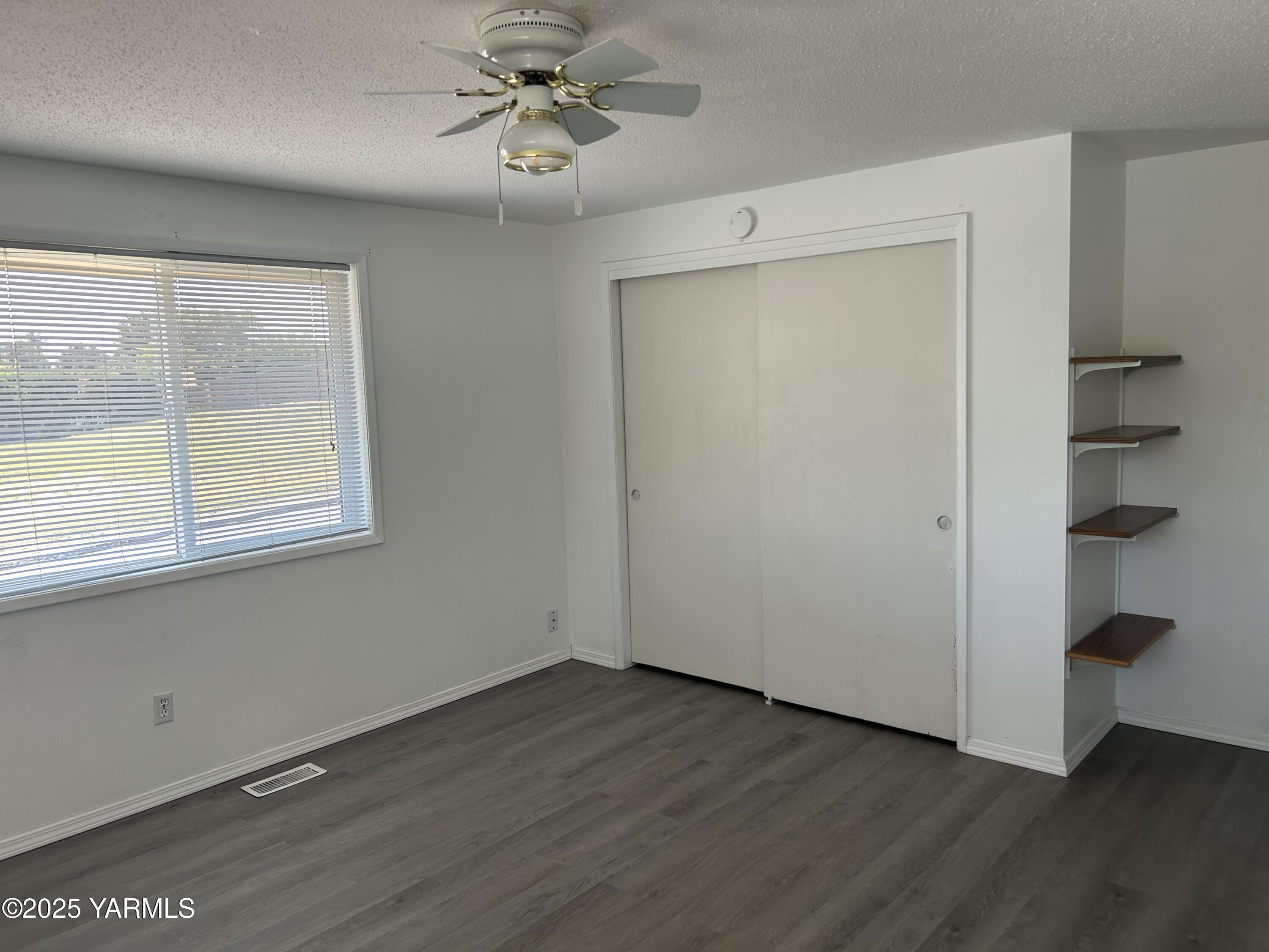 6505 Alpine Way Yakima, WA 98908 - Photo 11 of 18 a view of an empty room with a window and wooden floor