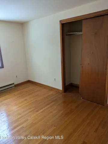 an empty room with wooden floor and closet