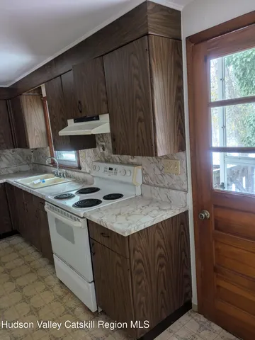 a kitchen with a sink a stove a refrigerator and a window