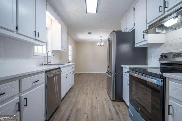 a kitchen with stainless steel appliances granite countertop a stove a sink and a refrigerator