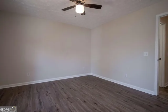 a view of a room with wooden floor and fan