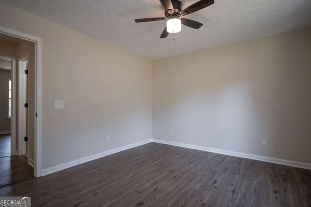 a view of a room with wooden floor and ceiling fan