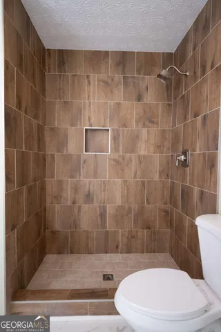 a white toilet sitting next to a bath tub