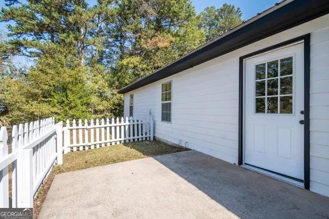 a view of a house with a small yard and wooden fence