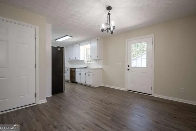 a view of a kitchen with a sink wooden floor and a window