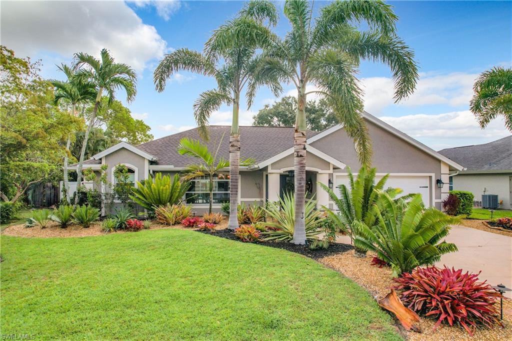 10231 Boca Circle Naples, FL 34109 - Photo 2 of 44 a front view of a house with a garden