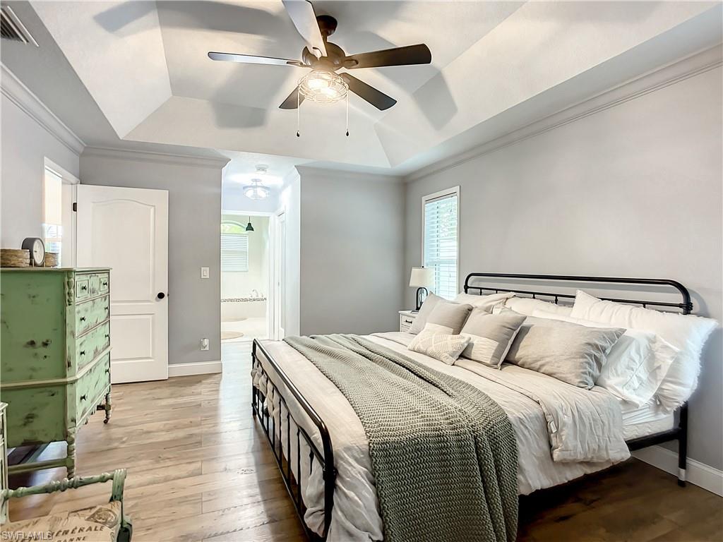 10231 Boca Circle Naples, FL 34109 - Photo 22 of 44 a bedroom with a bed and wooden floor