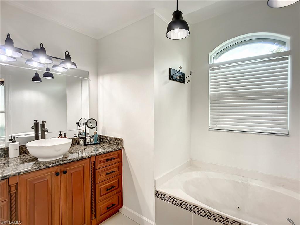 10231 Boca Circle Naples, FL 34109 - Photo 23 of 44 a bathroom with a granite countertop sink and a mirror