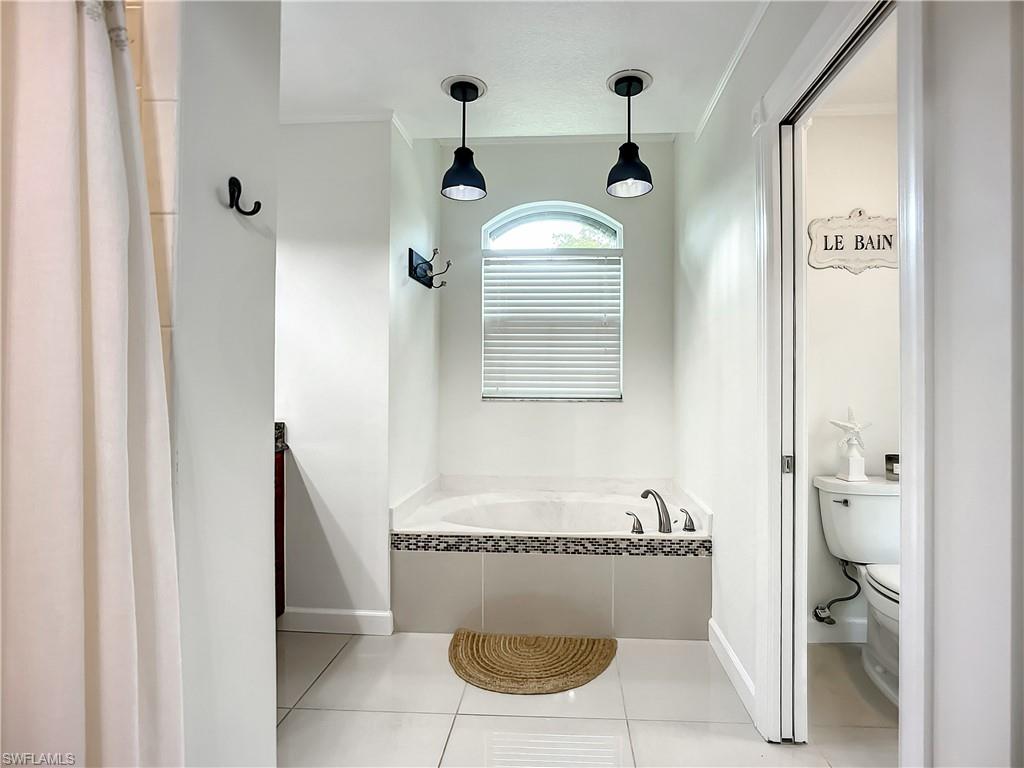 10231 Boca Circle Naples, FL 34109 - Photo 25 of 44 a bathroom with a granite countertop sink mirror vanity and toilet