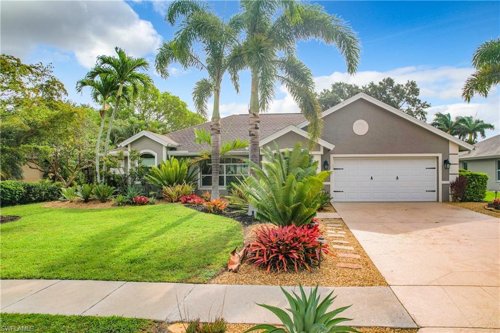 10231 Boca Circle Naples, FL 34109 - Photo 3 of 44 a front view of a house with a yard and potted plants