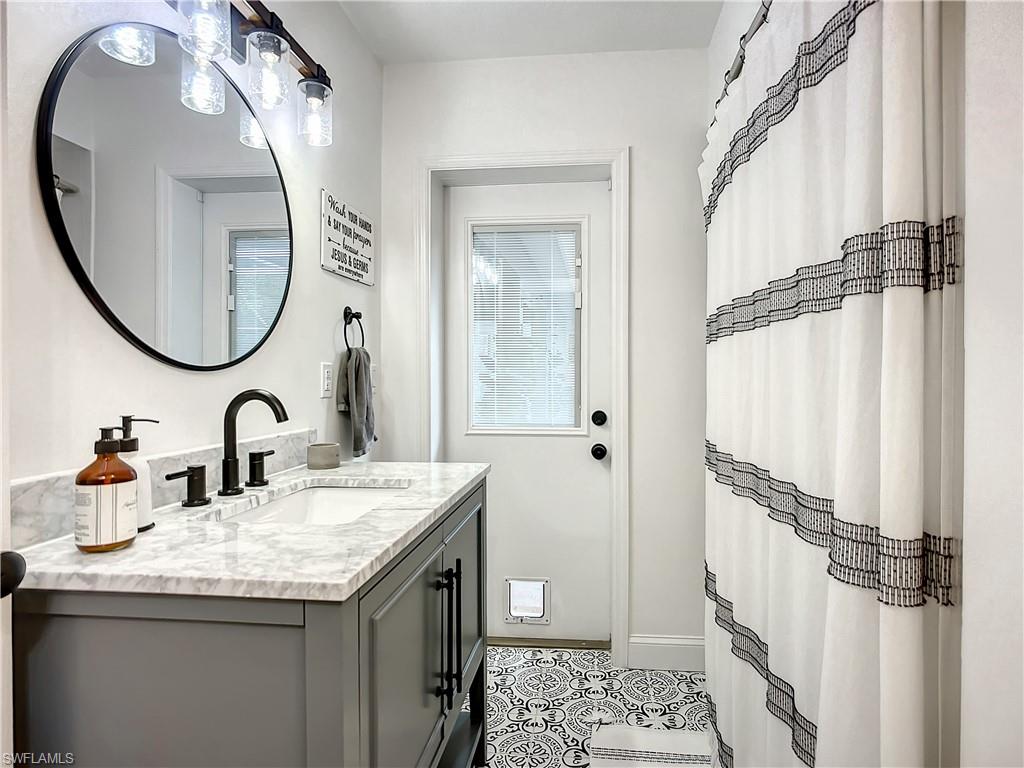 10231 Boca Circle Naples, FL 34109 - Photo 31 of 44 a bathroom with a granite countertop sink and a mirror