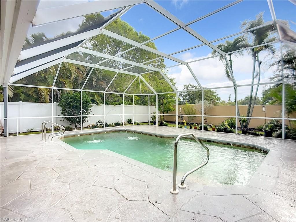 10231 Boca Circle Naples, FL 34109 - Photo 34 of 44 a view of a swimming pool with a patio and a yard