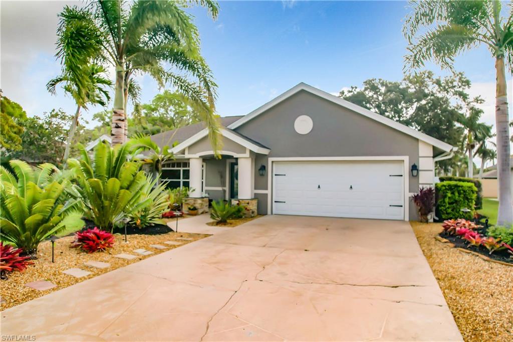 10231 Boca Circle Naples, FL 34109 - Photo 4 of 44 a front view of a house with a yard and a garage