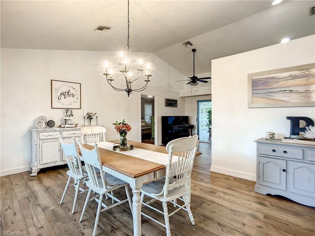 10231 Boca Circle Naples, FL 34109 - Photo 8 of 44 a view of a dining room with furniture a chandelier and wooden floor