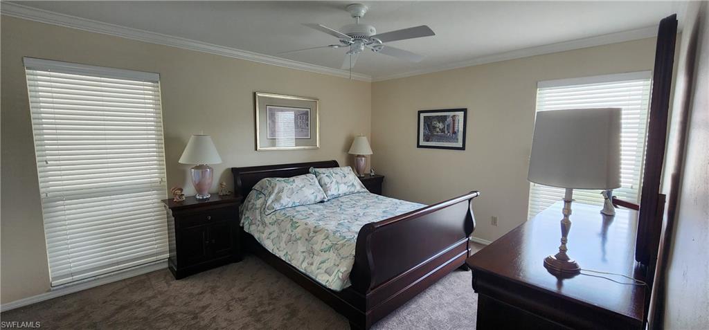 91 Georgetown Boulevard, Unit 91 Naples, FL 34112 - Photo 11 of 22 a bedroom with a bed and a mirror
