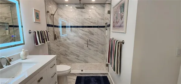 a bathroom with a granite countertop sink toilet and shower