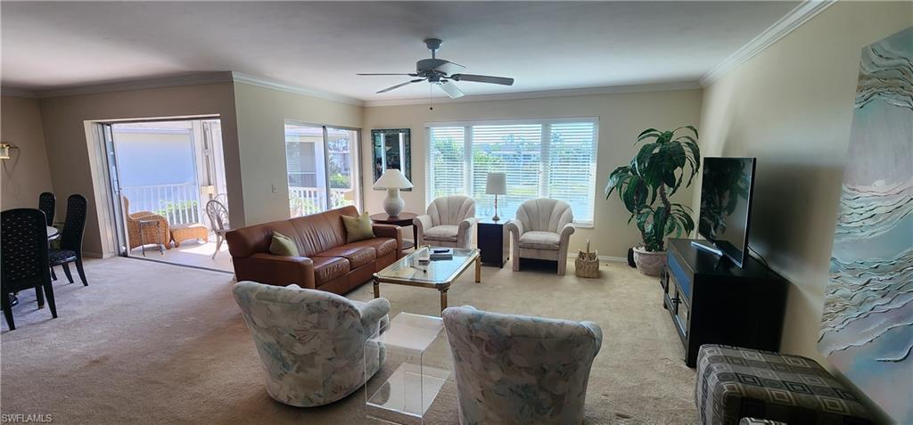 91 Georgetown Boulevard, Unit 91 Naples, FL 34112 - Photo 4 of 22 a living room with furniture a large window and a flat screen tv