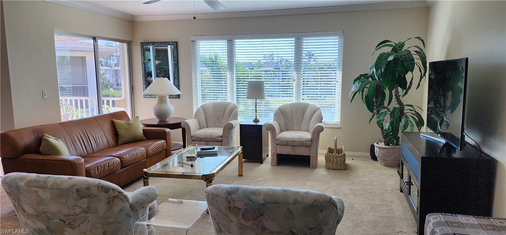 91 Georgetown Boulevard, Unit 91 Naples, FL 34112 - Photo 5 of 22 a living room with furniture potted plant and a large window
