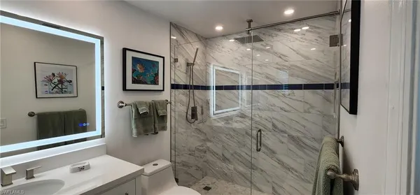 a bathroom with a shower sink and mirror