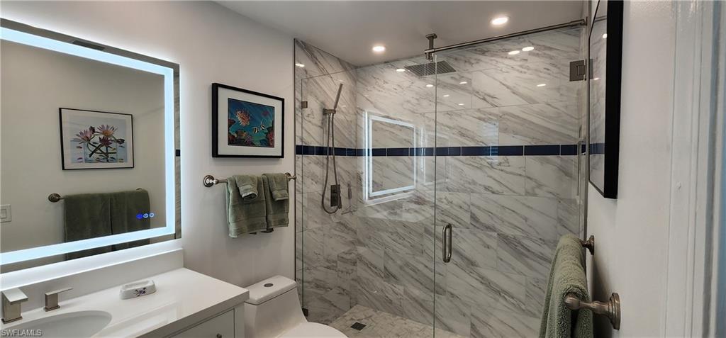 91 Georgetown Boulevard, Unit 91 Naples, FL 34112 - Photo 8 of 22 a bathroom with a shower sink and mirror