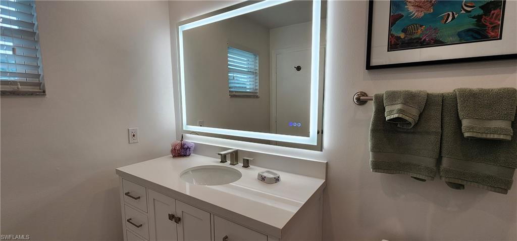 91 Georgetown Boulevard, Unit 91 Naples, FL 34112 - Photo 9 of 22 a bathroom with a sink and mirror