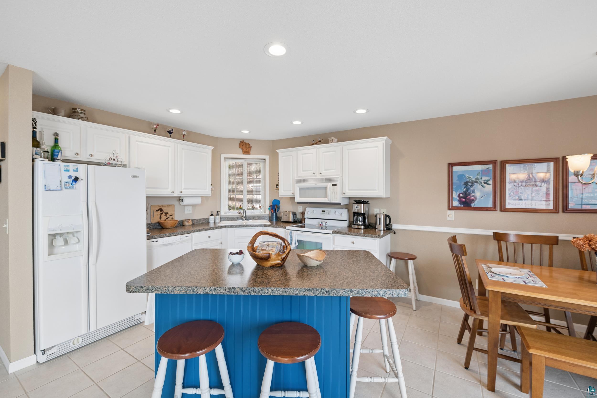 34590 Bay View Road, Unit 801 Bayfield, WI 54814 - Photo 10 of 36 Kitchen featuring white cabinetry, a blue island with a stone-finish countertop, stainless steel appliances, and tile flooring