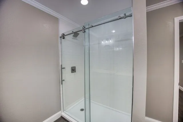 a bathroom with a glass shower door and sink