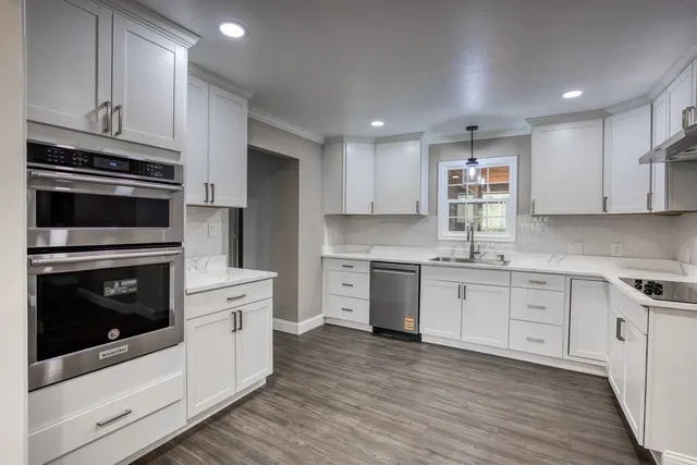 a kitchen with granite countertop a stove top oven sink and cabinets