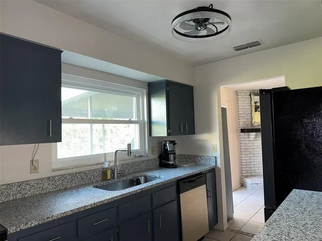 a kitchen with stainless steel appliances granite countertop a sink a window and cabinets