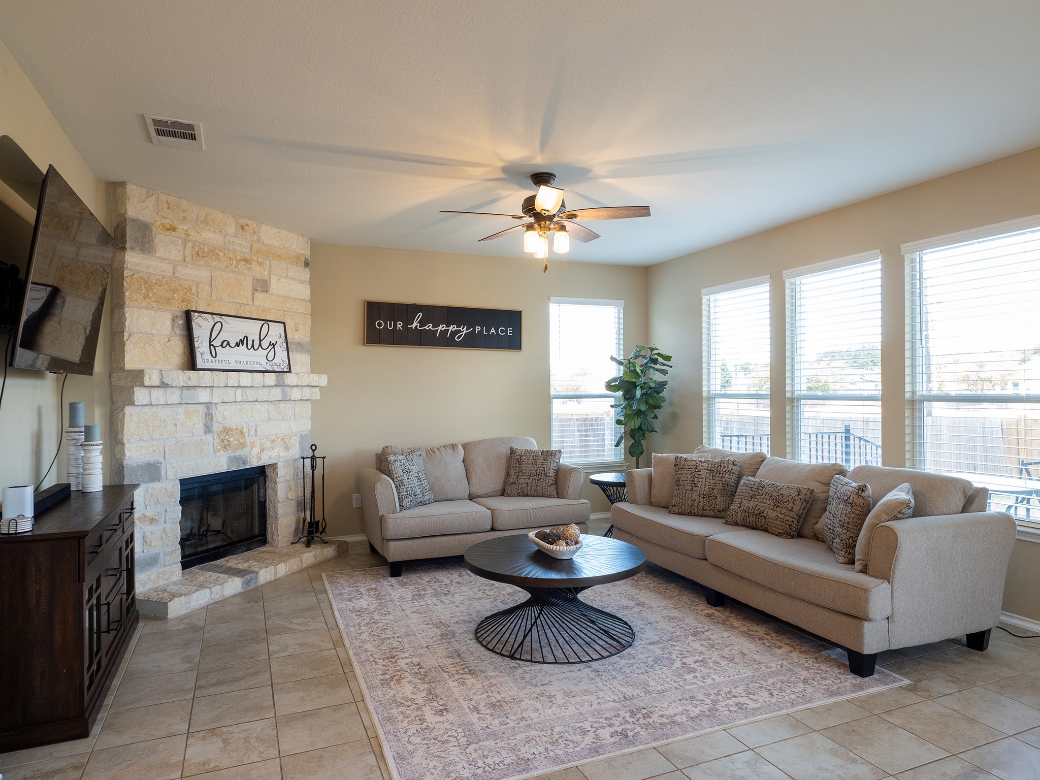 104 Rocroi Drive Georgetown, TX 78626 - Photo 3 of 40 A stone fireplace anchors this living space illuminated by large windows and recessed lighting.