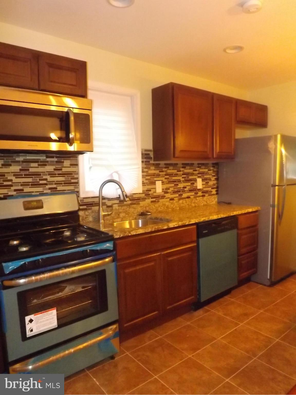 705 St Dunstans Road Baltimore, MD 21212 - Photo 6 of 21 a kitchen with granite countertop a stove and a cabinets