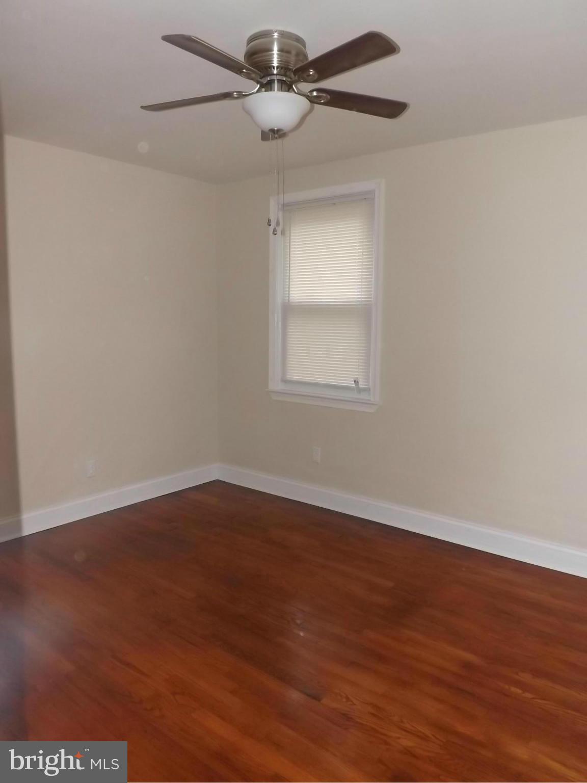 705 St Dunstans Road Baltimore, MD 21212 - Photo 10 of 21 an empty room with wooden floor ceiling fan and windows