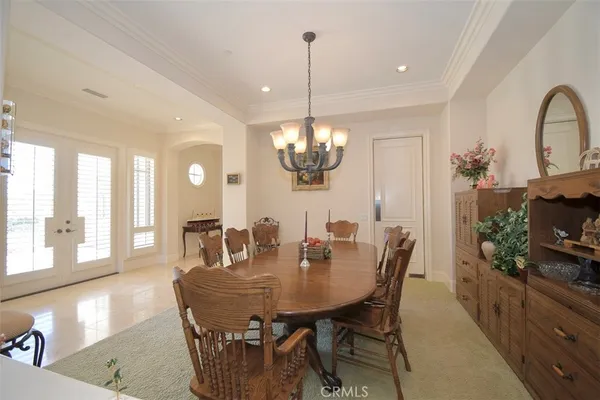 a dining room with furniture a chandelier and wooden floor
