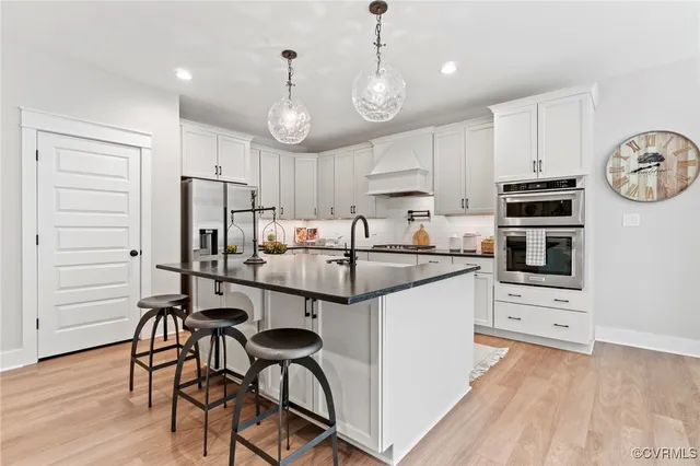 a kitchen with stainless steel appliances a stove a refrigerator and a microwave