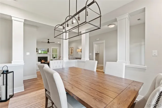 a view of a dining room and livingroom with furniture wooden floor a chandelier