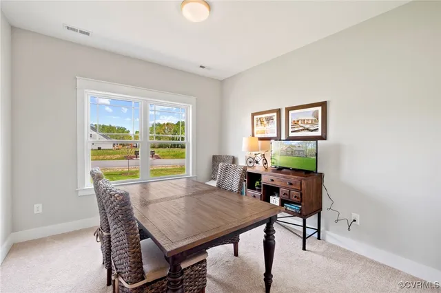a view of a dining room with furniture a rug and wooden floor