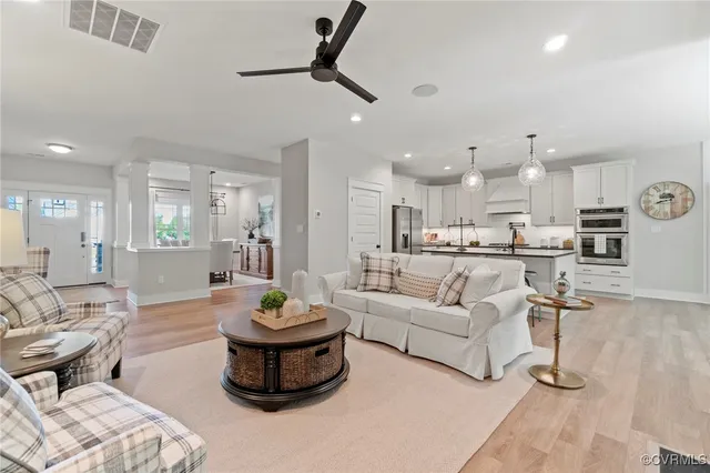 a living room with furniture and a view of kitchen