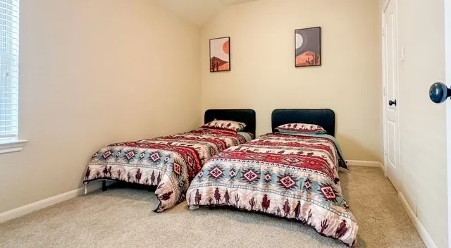 a bedroom with two beds and a dresser