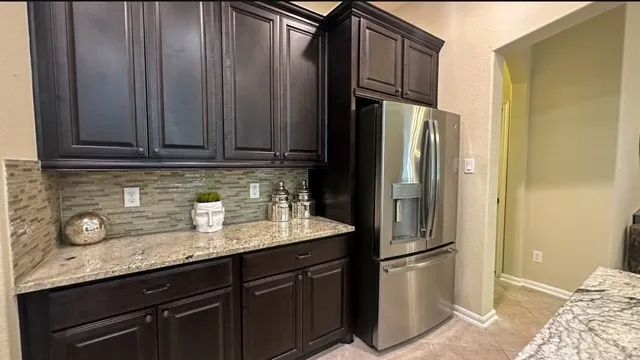 a kitchen with stainless steel appliances granite countertop a refrigerator and a sink